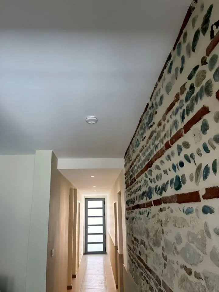 Mur en briques et galets remis à nu